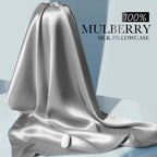 Draped silver-grey mulberry silk fabric showcasing its smooth, lustrous texture.