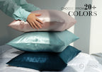 Stack of silk pillowcases in pink, mint, and navy — choose from 20+ colors.