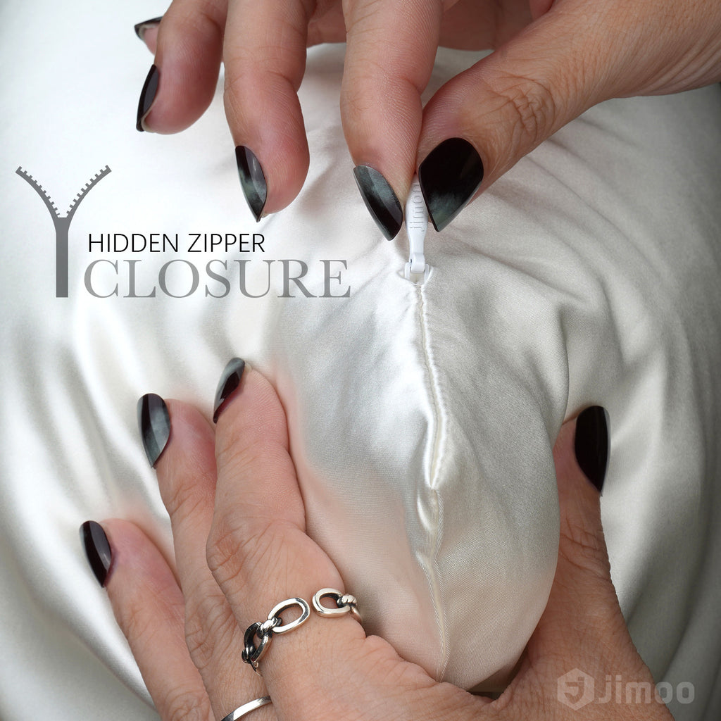Hands opening hidden zipper on pure white silk pillowcase — keeps pillow secure all night.